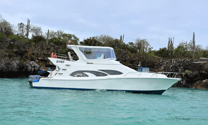 Ferry blanco con bandera de Ecuador atracado frente a una isla.