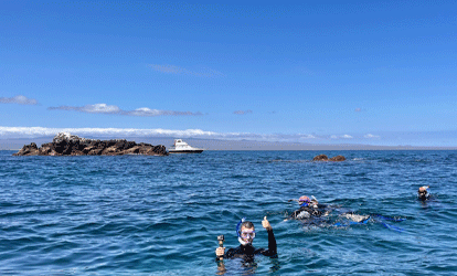 Turistas haciendo snorkeling cerca de ferry.